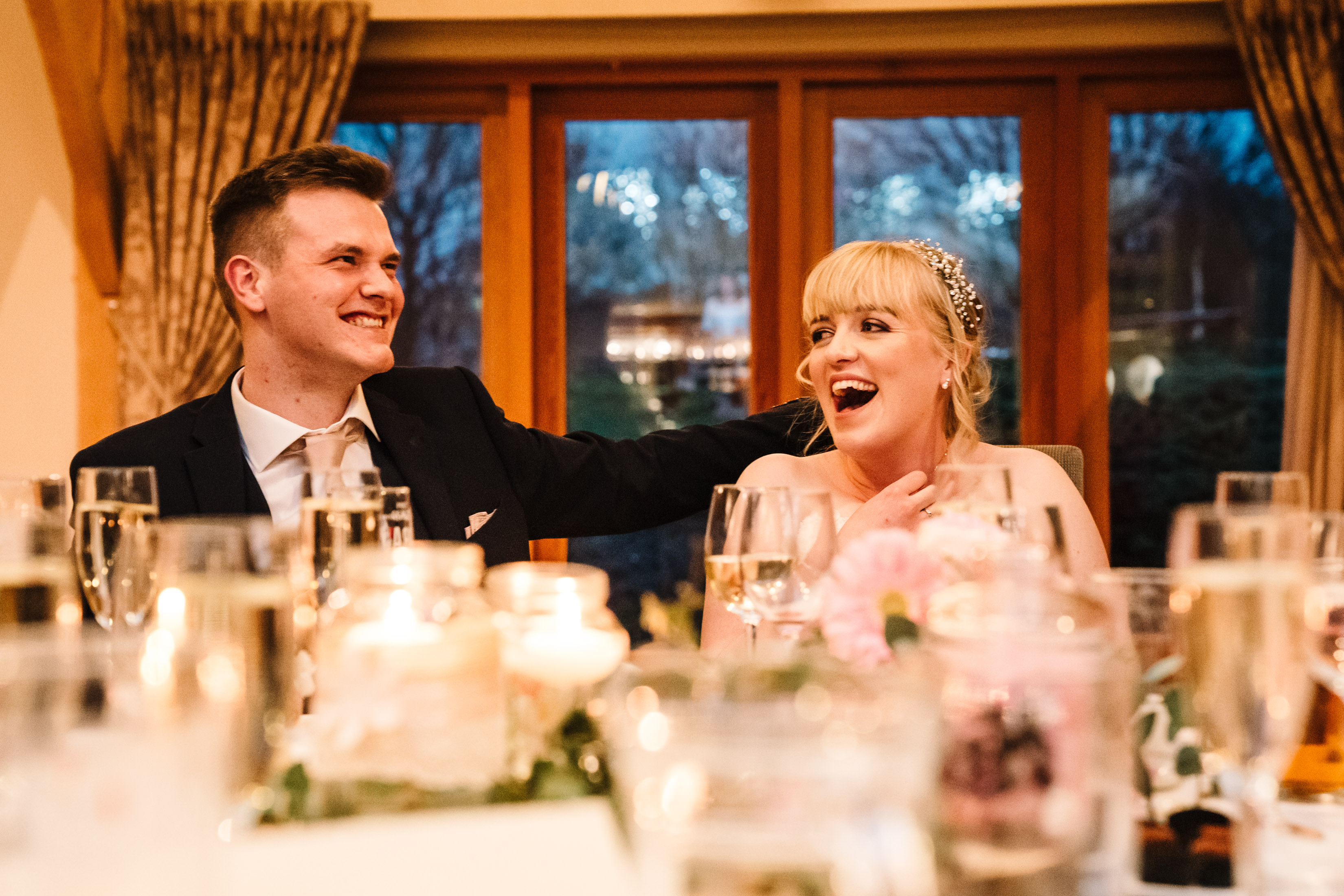 Bride and groom laughing during wedding speeches, the White Hart Inn