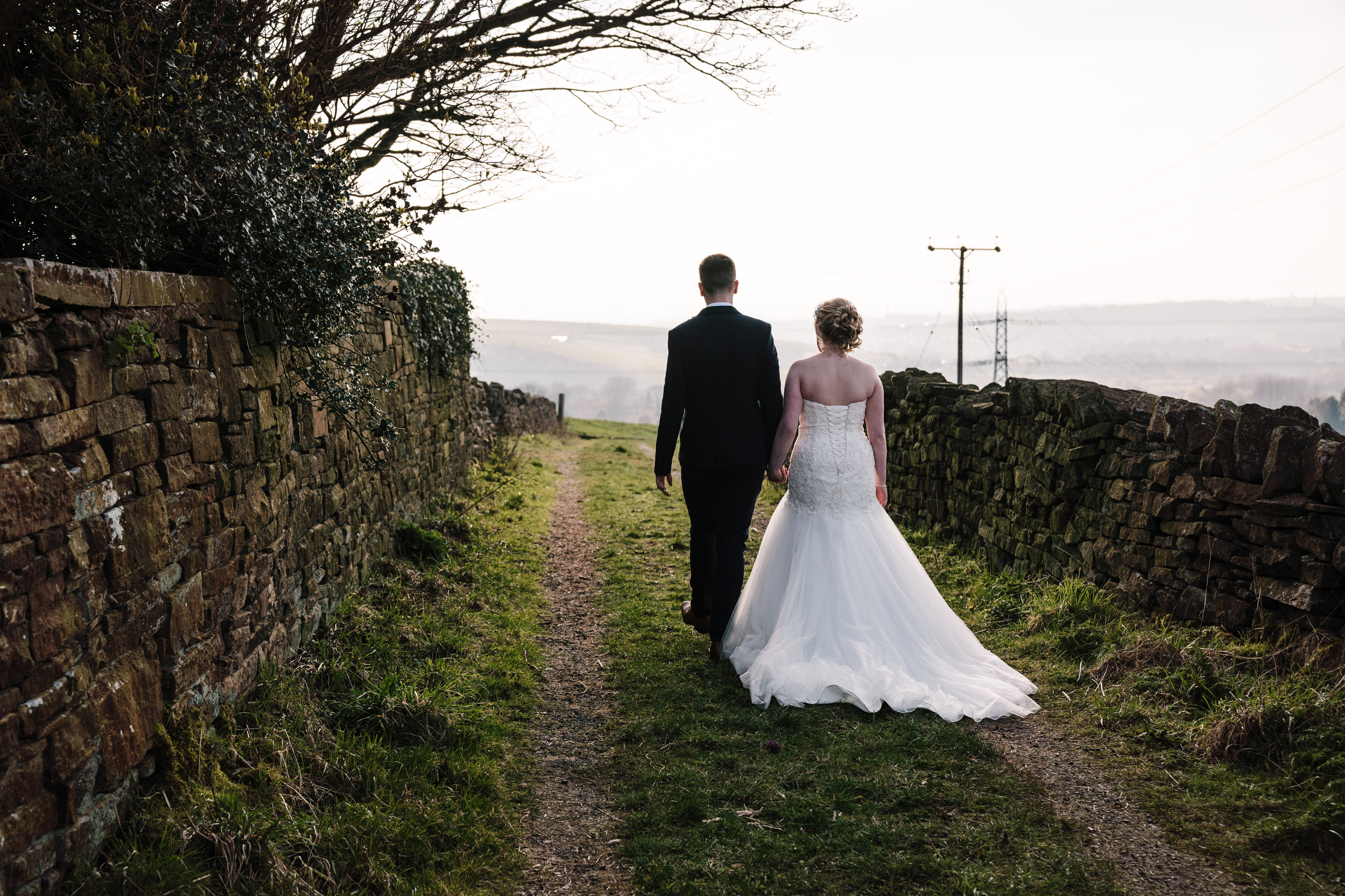 bride and groom walking down a track, Lydgate wedding