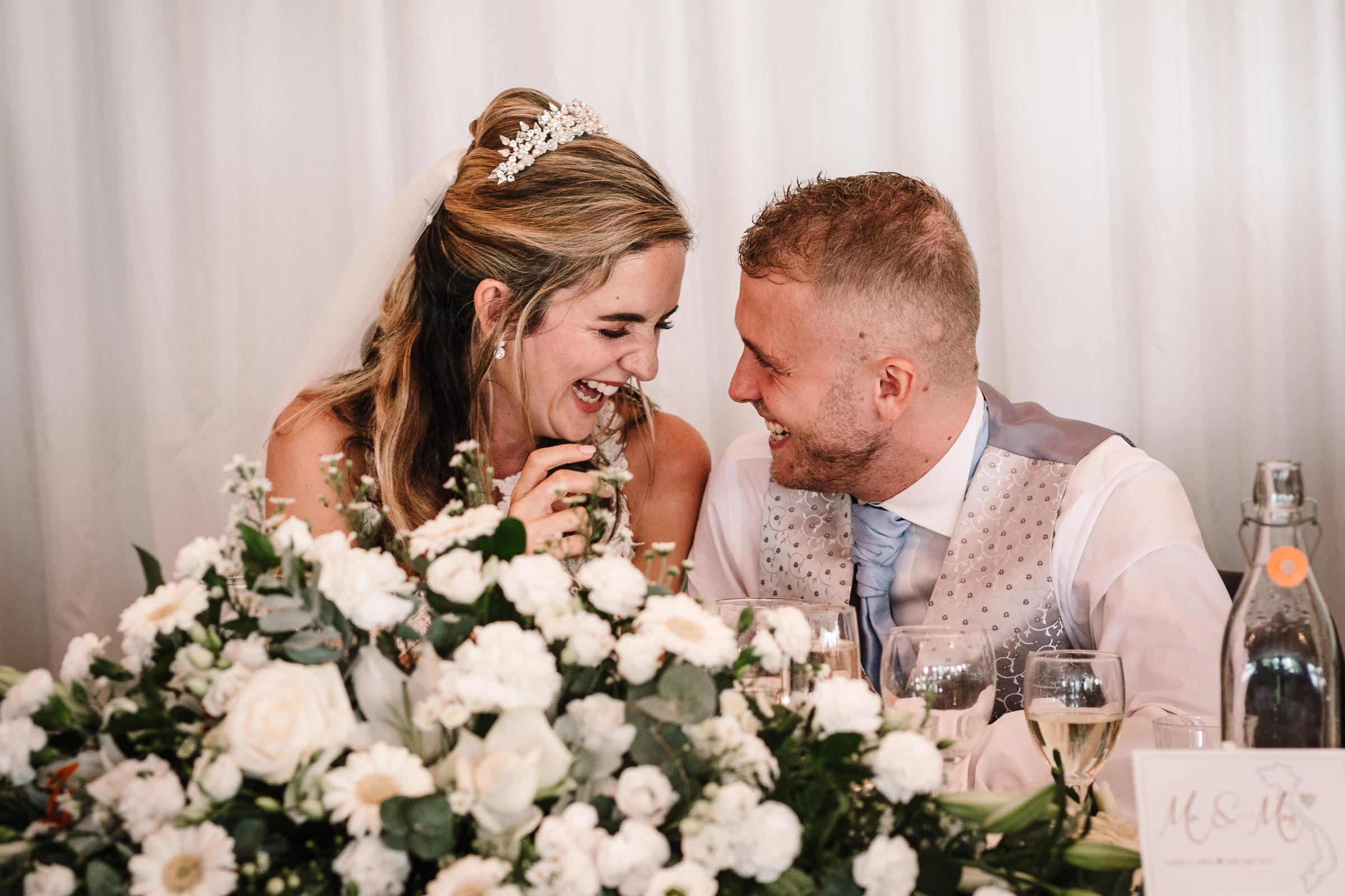 bride and groom laughing during best man speech