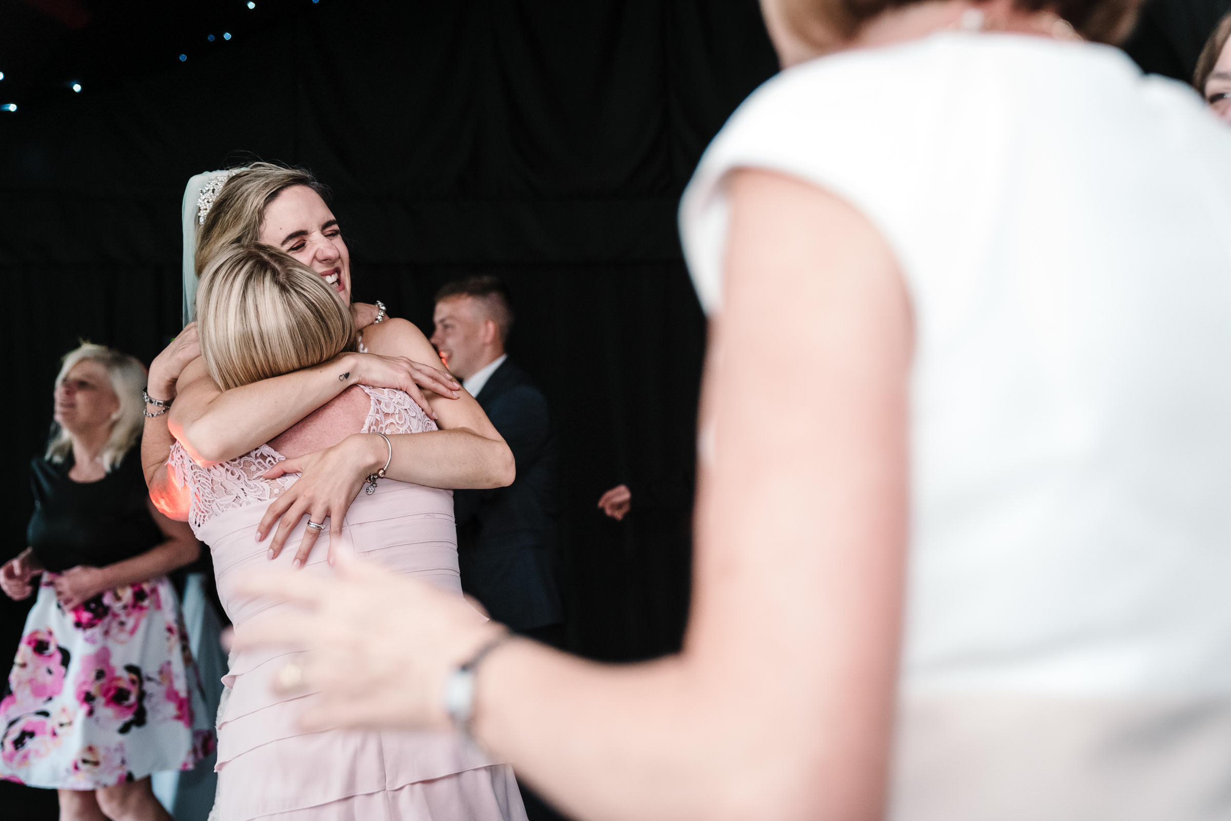 bride hugging guest on dancefloor