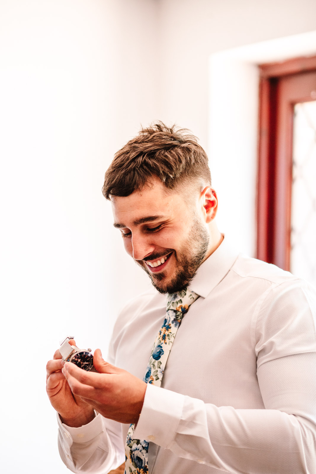 groom smiling, looking at new watch