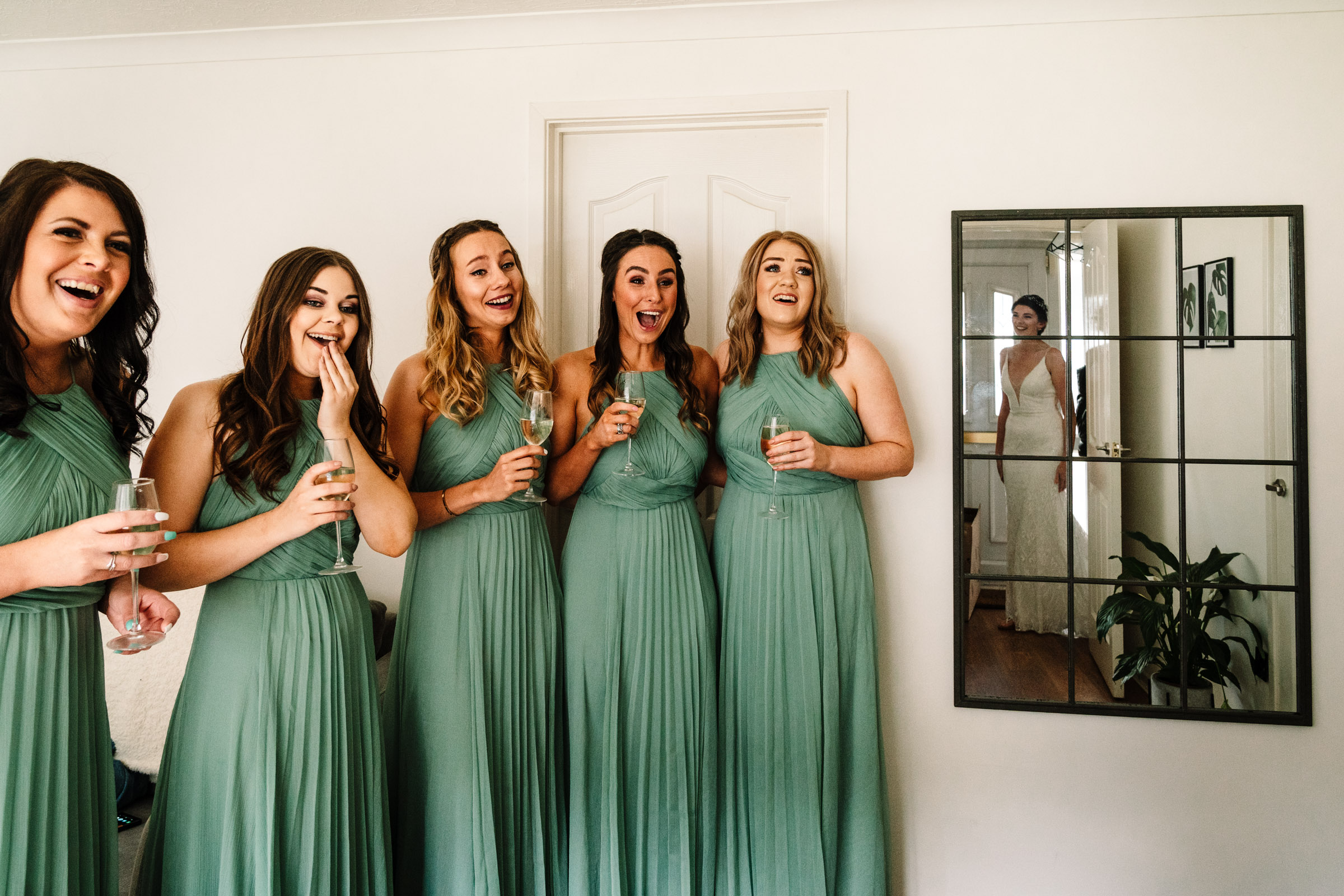 bridesmaids see the bride in her wedding dress for the first time