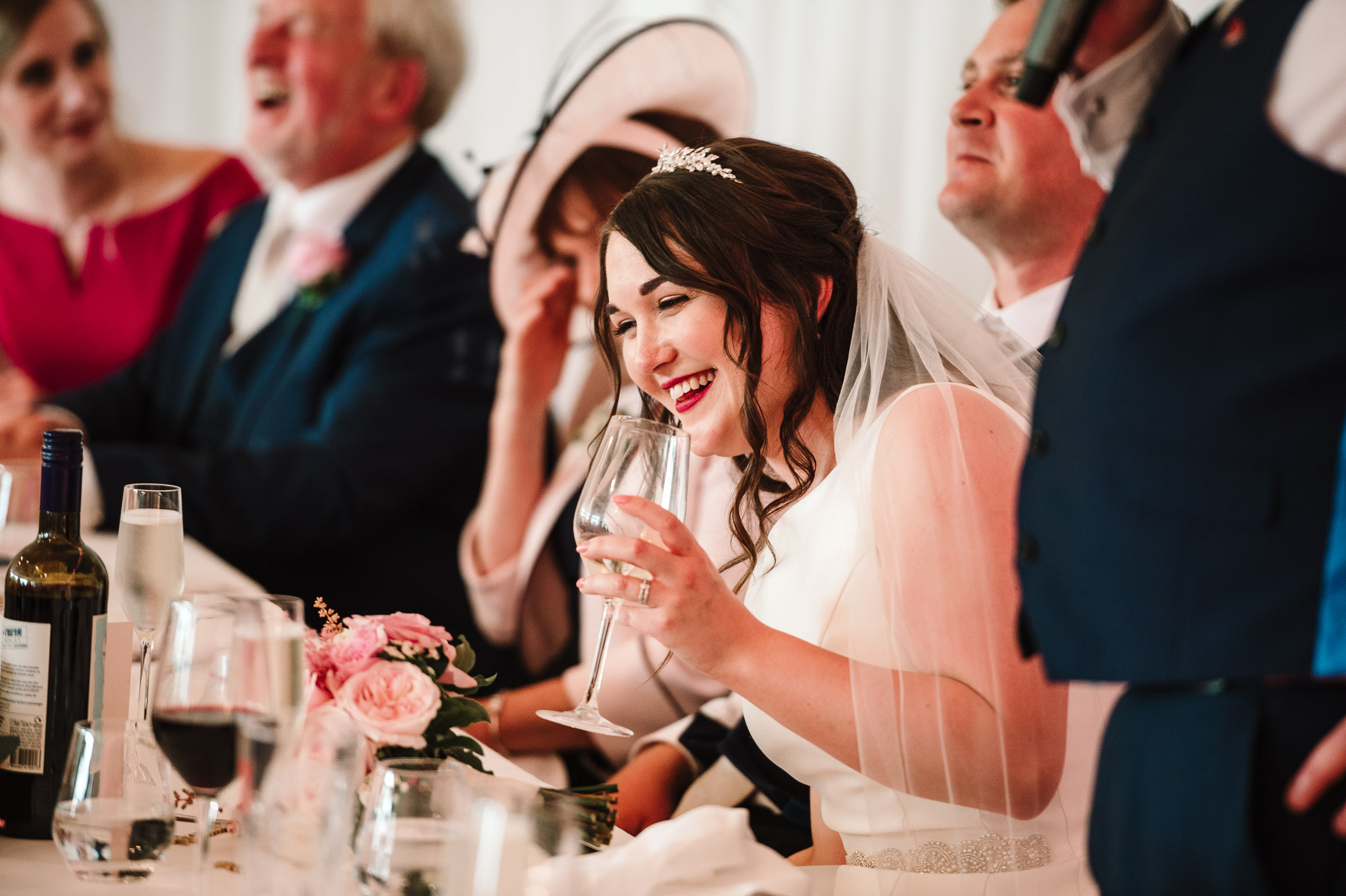 bride laughing at grooms speech